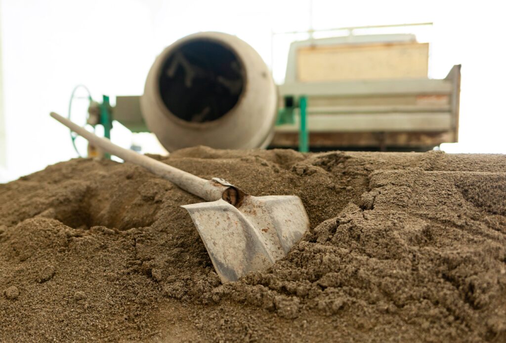 building sand pile with cement mixer in background